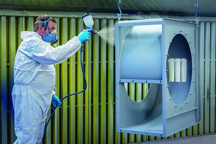 Mitarbeiter beschichtet ein Bauteil in der Fertigung der KS Metalltechnik