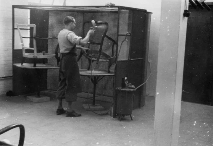 Historische Aufnahme eines Mitarbeiters bei der Arbeit an einem Spritzstand